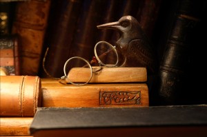 Vintage still life with old spectacles on desk set against books